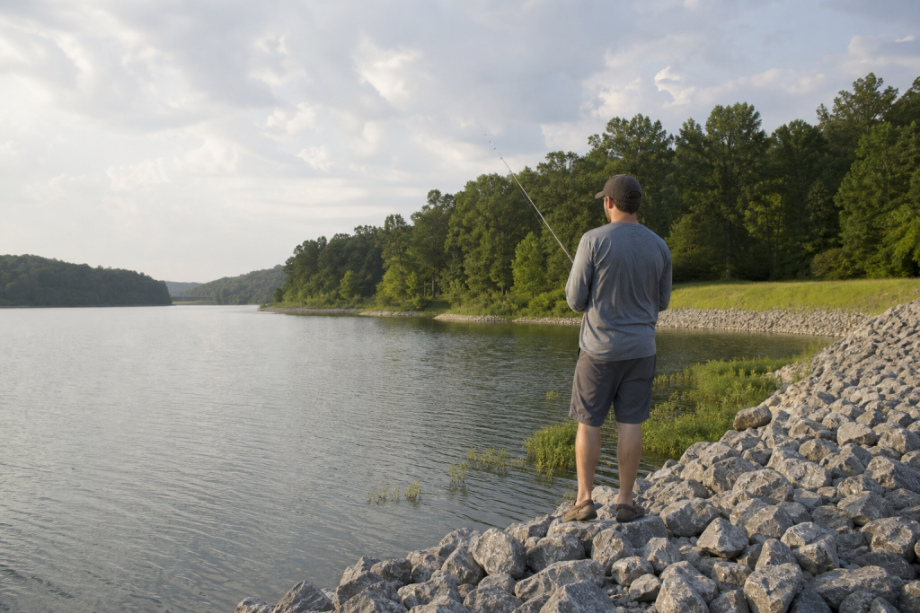 Angler studying an unfamiliar lake shoreline for fishing spots