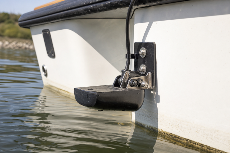 Fish finder transducer mounted on a boat transom at the waterline