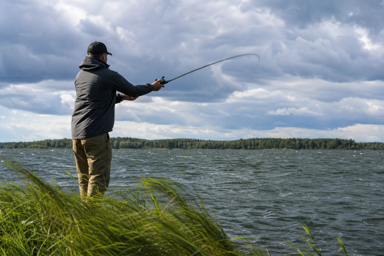 Angler casting for bass on a windy lake with choppy water